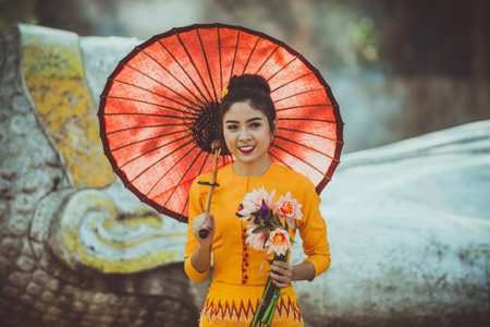 Beautiful woman with burma traditional dress from Myanmar visiting the buddha statueのeditorial素材