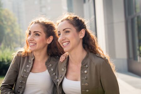 Beautiful twin sisters bonding and having fun outdoors