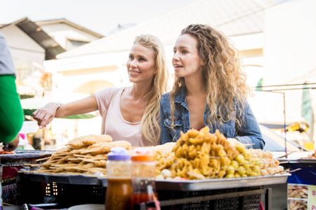 Young happy tourists exploring a south-east asian  foodの写真素材