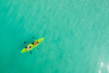 Couple kayaking on  blue waterの写真素材
