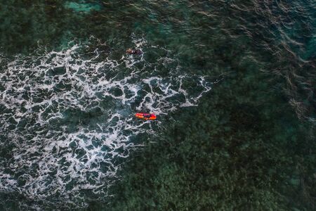 Surfer at Clpud 9 pier in Siargao, Philippines - Aerial view of surfers swimming into the oceanの写真素材