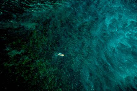 Surfer at Clpud 9 pier in Siargao, Philippines - Aerial view of surfers swimming into the ocean