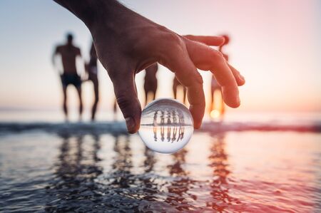 Artistic portrait of friends with reflection inside a glass sphereの写真素材