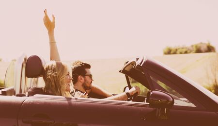 Couple driving on a convertible car and having fun