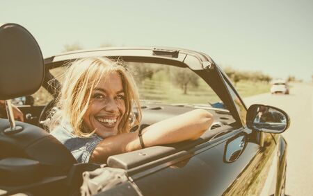 Couple driving on a convertible car and having funの写真素材