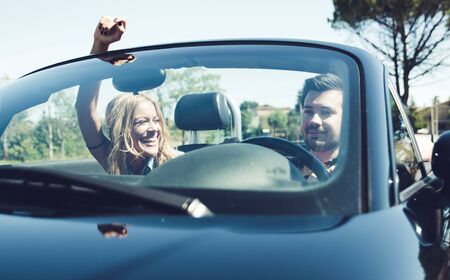 Couple driving on a convertible car and having funの写真素材