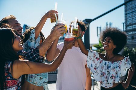 Group of friends having fun on the rooftop of a beautiful penthouseの写真素材