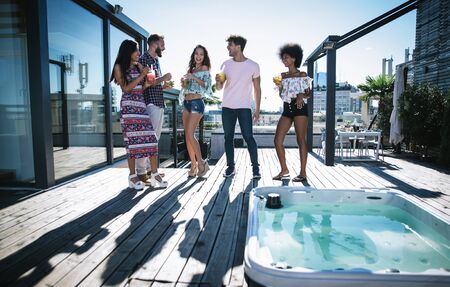 Group of friends having fun on the rooftop of a beautiful penthouse