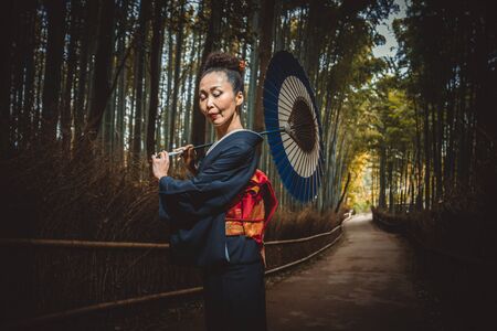 Beautiful japanese senior woman walking in the bamboo forestの写真素材