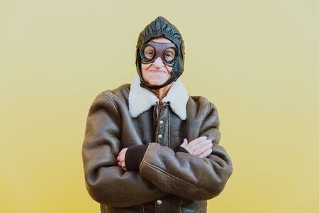 Funny portraits with old grandmother. Senior woman acting as an aviator from the first world war.の写真素材