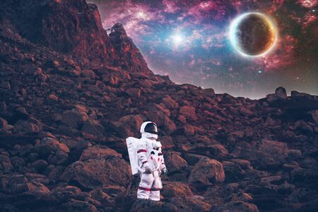 Astronaut exploring a new planet. Searching for a new home for humanity. Concept about science and...