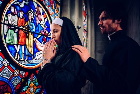 Nun and priest praying and spending time in the monastery