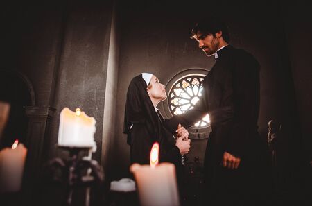 Nun and priest praying and spending time in the monastery