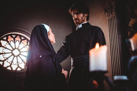 Nun and priest praying and spending time in the monastery