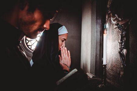 Nun and priest praying and spending time in the monastery
