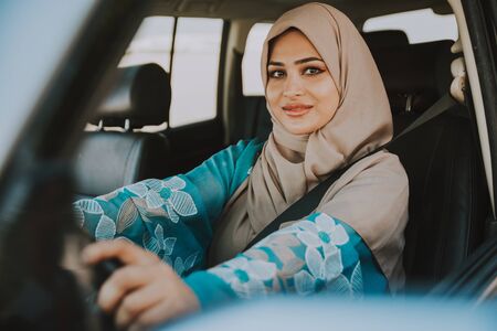 Beautiful woman in Dubai wearing abaya traditional female dress driving the car. Concept about uae and women rightsの写真素材