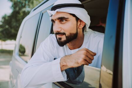 Handsome man with uae traditional outfit driving in Dubai. Middle eastern man with kandura in the carの写真素材
