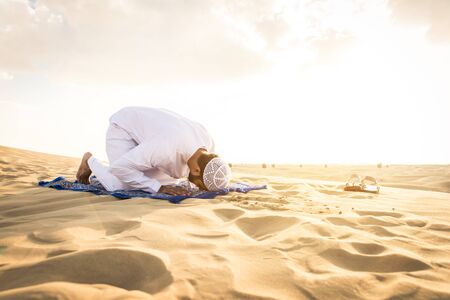 Arabian men witk kandora walking in the desert - Portrait of two middle eastern adults with traditional arabic dressの写真素材