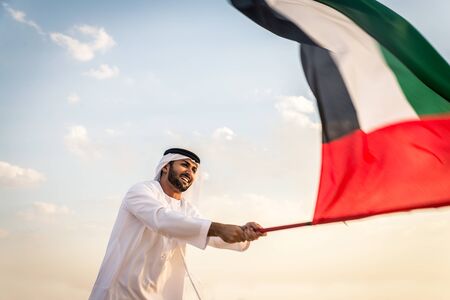 Arabian men witk kandora walking in the desert - Portrait of two middle eastern adults with traditional arabic dressの写真素材