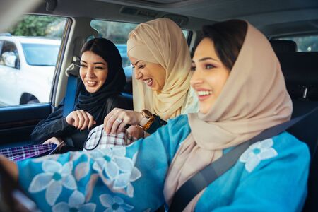 Arabic women with abaya bonding and having fun outdoors - Happy middleastern friends meeting and...