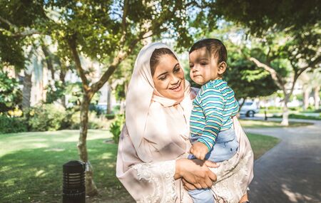 Middle eastern family with traditional dress having fun outdoors - Modern islamic mom and son in Dubaiの写真素材