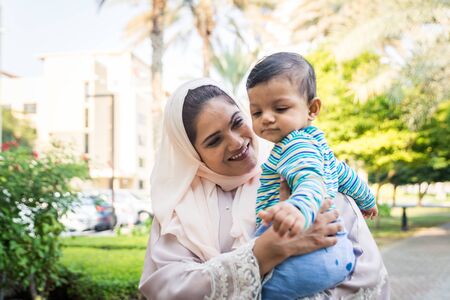 Middle eastern family with traditional dress having fun outdoors - Modern islamic mom and son in Dubaiの写真素材