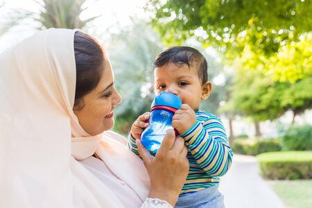 Middle eastern family with traditional dress having fun outdoors - Modern islamic mom and son in...