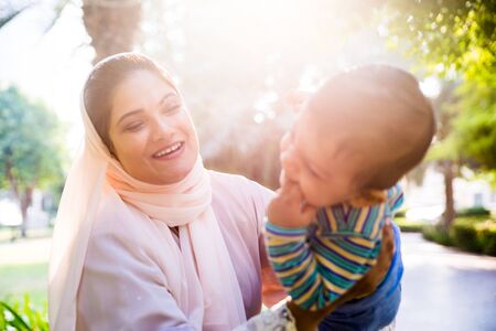 Middle eastern family with traditional dress having fun outdoors - Modern islamic mom and son in...