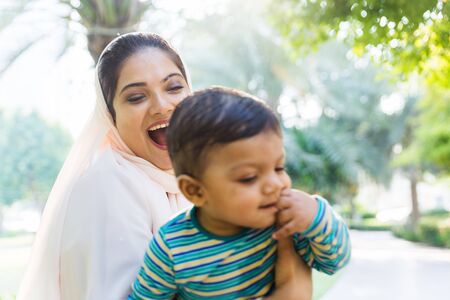 Middle eastern family with traditional dress having fun outdoors - Modern islamic mom and son in...