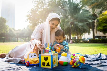 Middle eastern family with traditional dress having fun outdoors - Modern islamic mom and son in...