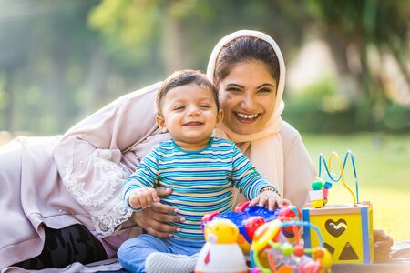 Middle eastern family with traditional dress having fun outdoors - Modern islamic mom and son in...