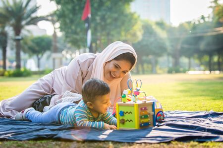 Middle eastern family with traditional dress having fun outdoors - Modern islamic mom and son in Dubaiの写真素材