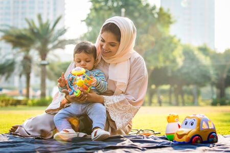 Middle eastern family with traditional dress having fun outdoors - Modern islamic mom and son in...