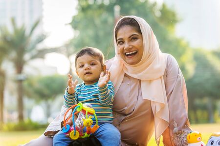 Middle eastern family with traditional dress having fun outdoors - Modern islamic mom and son in...