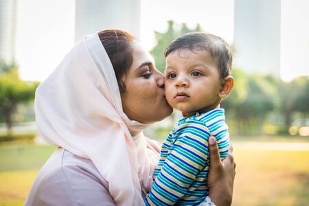 Middle eastern family with traditional dress having fun outdoors - Modern islamic mom and son in Dubaiの写真素材
