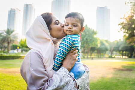 Middle eastern family with traditional dress having fun outdoors - Modern islamic mom and son in Dubaiの写真素材
