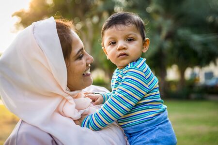 Middle eastern family with traditional dress having fun outdoors - Modern islamic mom and son in Dubaiの写真素材