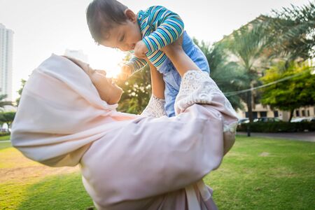 Middle eastern family with traditional dress having fun outdoors - Modern islamic mom and son in Dubaiの写真素材