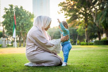 Middle eastern family with traditional dress having fun outdoors - Modern islamic mom and son in Dubaiの写真素材