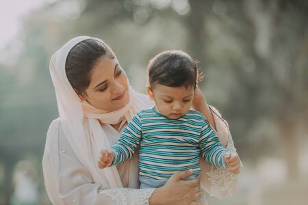 Middle eastern family with traditional dress having fun outdoors - Modern islamic mom and son in Dubaiの写真素材