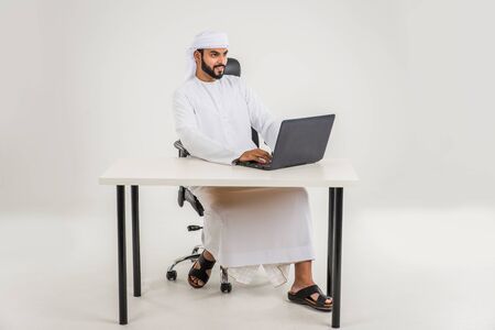 Middle eastern man with traditional emirates dresses posing in a photographic studio - Concepts about lifestyle, happiness and family relationship in the UAEの写真素材