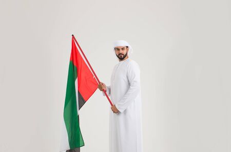 Middle eastern man with traditional emirates dresses posing in a photographic studio - Concepts about lifestyle, happiness and family relationship in the UAEの写真素材