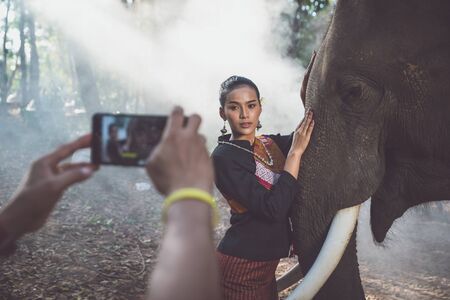 Beautiful thai woman spending time with the elephant in the jungleの写真素材