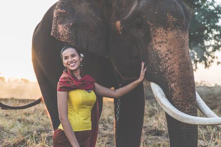 Beautiful thai woman spending time with the elephant in the jungle