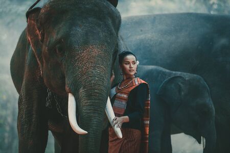Beautiful thai woman spending time with the elephant in the jungle