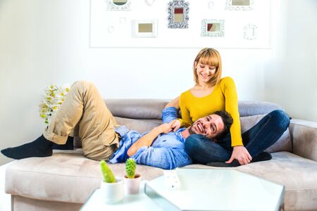 Two young adults at home - Beautiful couple relaxing and watching a movie at tvの写真素材