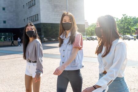 Group of asian girls going out after quarantine during coronavirus period. Young women outdoor with...
