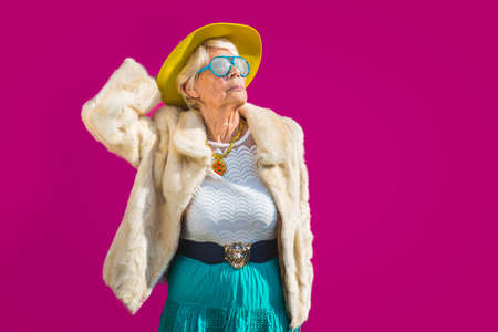 Happy and playful senior woman having fun - Portrait of a beautiful lady above 70 years old with...
