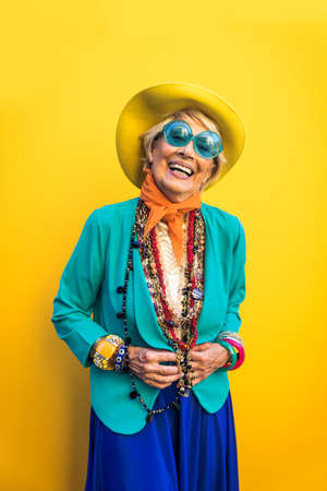 Happy and playful senior woman having fun - Portrait of a beautiful lady above 70 years old with stylish clothes, concepts about senior peopleの写真素材