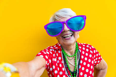 Happy and playful senior woman having fun - Portrait of a beautiful lady above 70 years old with...